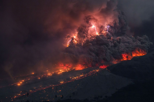 Uma tempestade de raios irrompe dentro da nuvem de cinzas em uma erupção de um vulcão na Indonésia. Imagem via mirror.co.uk